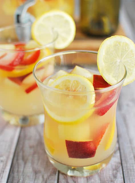 Pineapple Lemonade Sangria by Fake Ginger - Nothing screams summer more than frosty fruity drinks. Wine slushies, mules, sangria,  mimosas, cocktails, margaritas, and more! Graduations, Memorial Day, Fourth of July, or just a summer gathering with friends and family are all great reasons to throw a summer party.  No summer party is complete without fruity, slushy, cold drinks. You'll love these 10 summer drink recipes.  You'll be happy you tried them all. #summerdrinks #summerdrinkrecipes #foodanddrink #frozendrinks #wineslushies #frozencocktails #cocktails #partydrinks #partydrinkrecipes #HWS #healthywealthyskinny